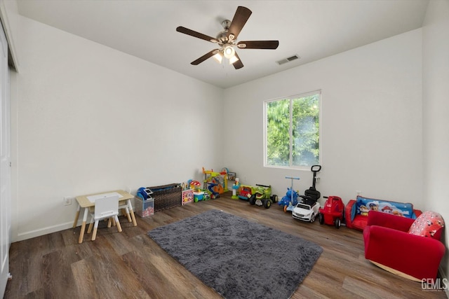 recreation room with baseboards, ceiling fan, visible vents, and wood finished floors