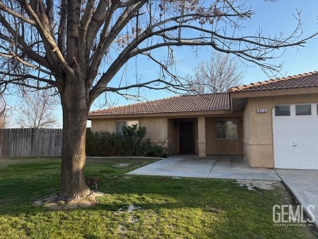 ranch-style house featuring a garage, a tile roof, fence, a front lawn, and stucco siding