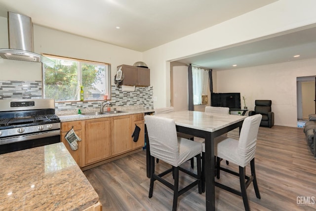 5435 Rd 37, Alpaugh, CA 93201 - kitchen featuring gas stove, wall chimney range hood, decorative backsplash, wood finished floors, and recessed lighting