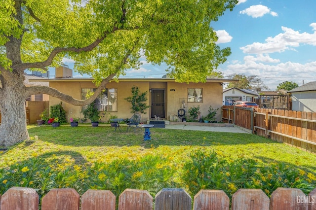 ranch-style home featuring stucco siding, fence, and a front lawn