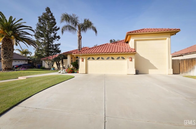 mediterranean / spanish-style home with a tile roof, stucco siding, concrete driveway, an attached garage, and a front yard