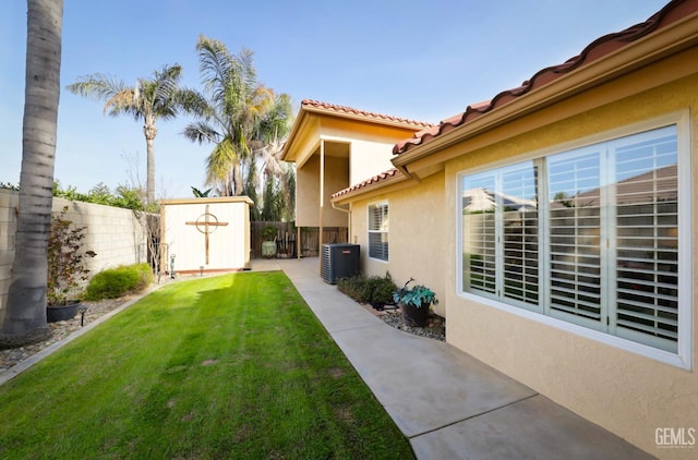 view of yard featuring a storage shed, a fenced backyard, cooling unit, and an outbuilding