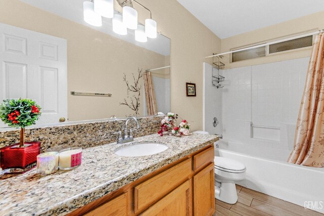 full bath with toilet, wood finished floors, shower / tub combo, and vanity