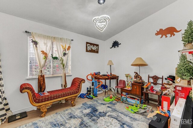 interior space featuring baseboards, wood finished floors, and a notable chandelier