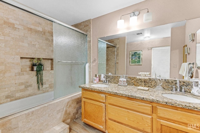 bathroom featuring a sink, tiled shower / bath combo, double vanity, and visible vents