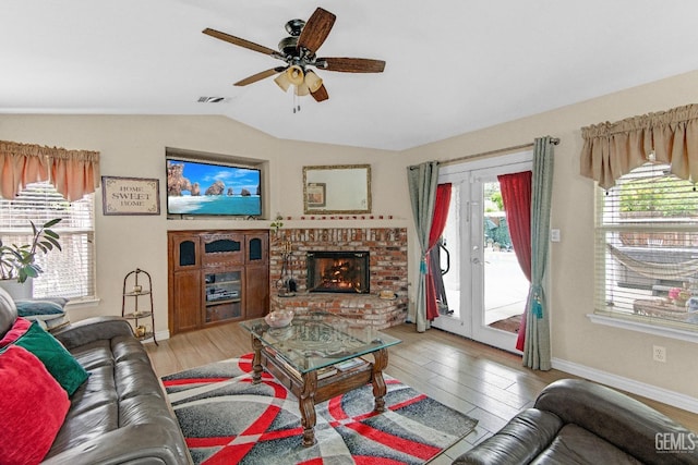 living room with ceiling fan, visible vents, lofted ceiling, and light wood-type flooring