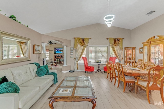 living room with ornate columns, visible vents, plenty of natural light, and vaulted ceiling