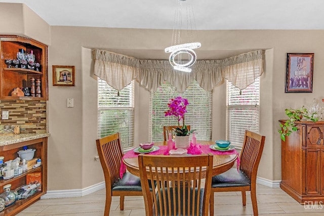 dining room featuring an inviting chandelier and baseboards