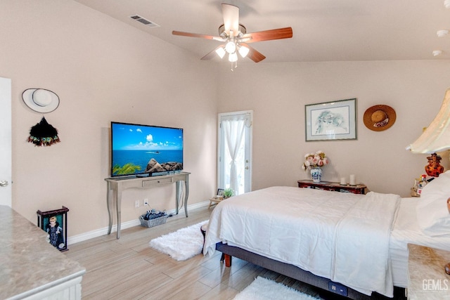 bedroom with ceiling fan, light wood finished floors, visible vents, baseboards, and vaulted ceiling