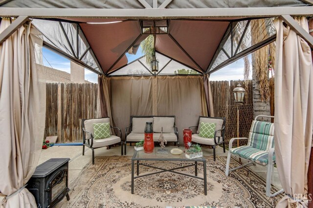 view of patio with a gazebo, an outdoor living space, and fence