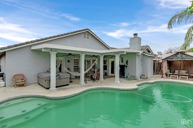 rear view of house with a gazebo, ceiling fan, stucco siding, an outdoor living space, and a patio