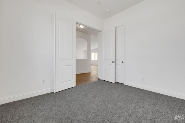 unfurnished bedroom featuring dark colored carpet