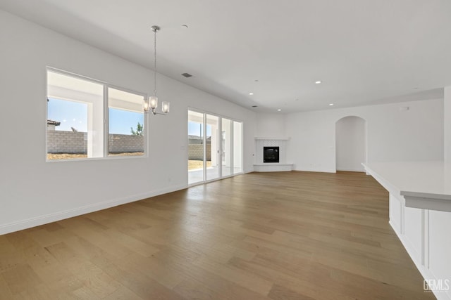 unfurnished living room featuring hardwood / wood-style floors and a chandelier