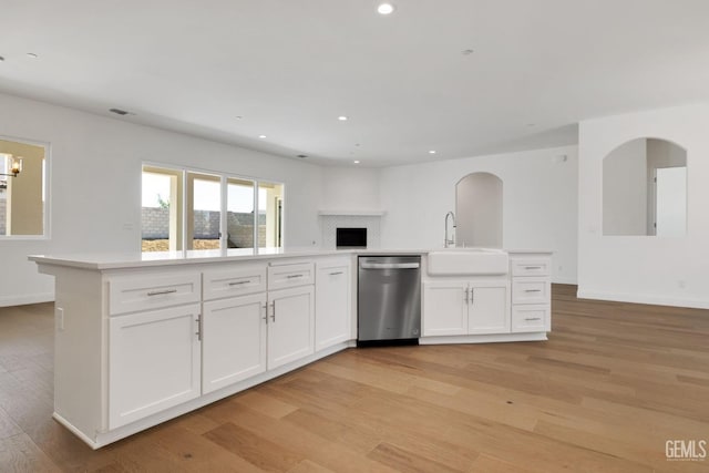 kitchen with white cabinetry, dishwasher, sink, and light hardwood / wood-style flooring