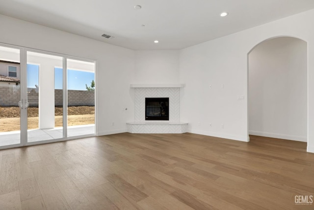 unfurnished living room featuring light hardwood / wood-style flooring and a fireplace