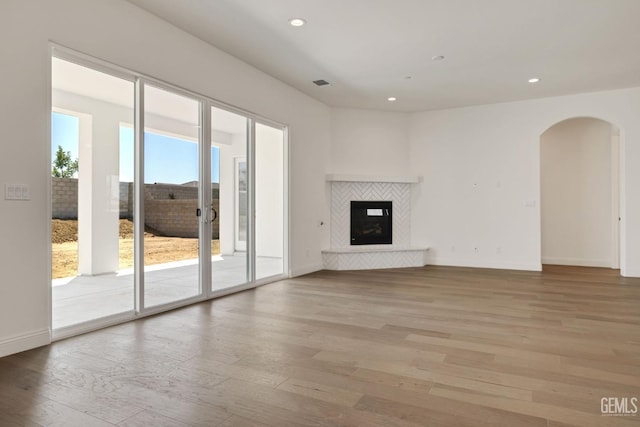 unfurnished living room featuring a fireplace and light hardwood / wood-style flooring