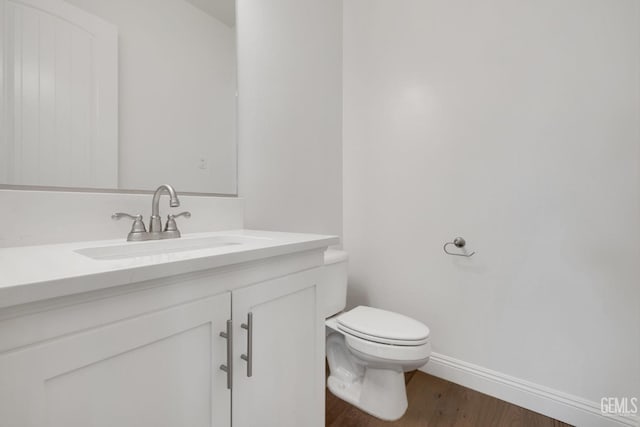 bathroom featuring vanity, toilet, and hardwood / wood-style floors