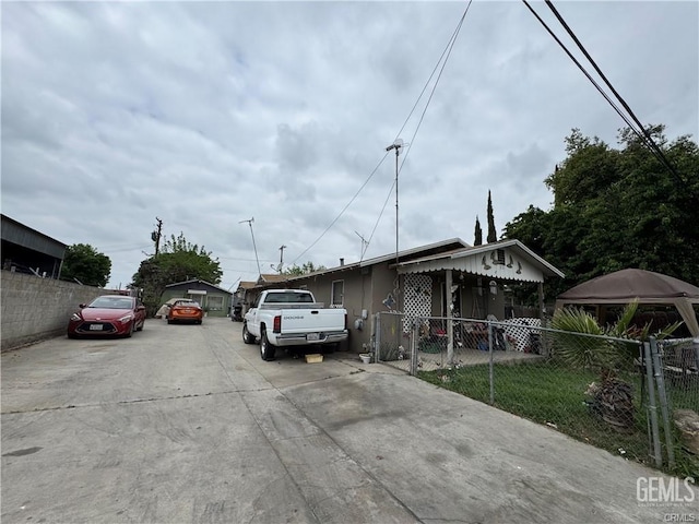 view of front of home featuring concrete driveway and fence private yard