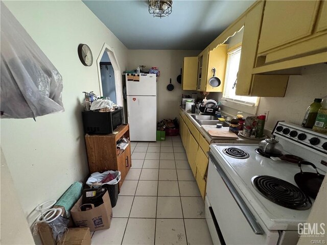 kitchen with light tile patterned floors, white appliances, a sink, and under cabinet range hood