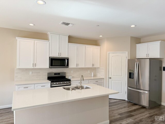 kitchen featuring stainless steel appliances, white cabinetry, and a kitchen island with sink