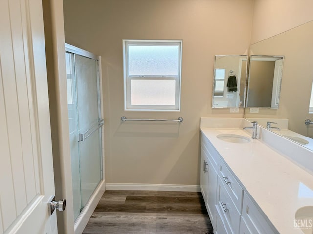 bathroom with hardwood / wood-style flooring, vanity, and an enclosed shower