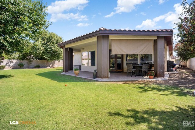 rear view of property featuring a patio area and a yard