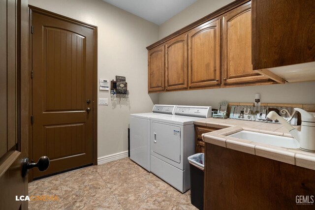 laundry room with cabinets, separate washer and dryer, and sink