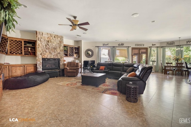 living room with ceiling fan, a fireplace, a healthy amount of sunlight, and tile patterned flooring