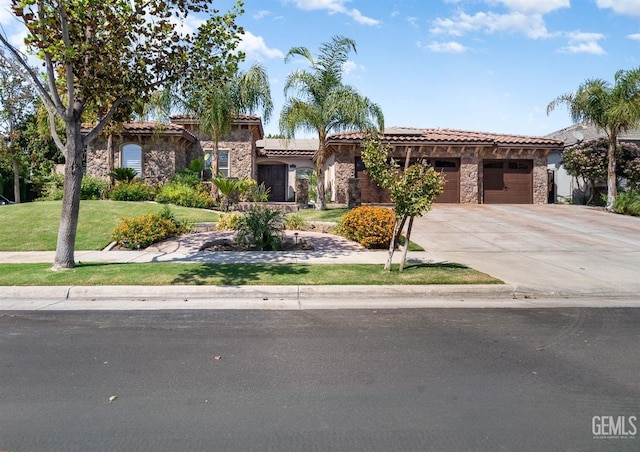 mediterranean / spanish-style house featuring a front yard and a garage