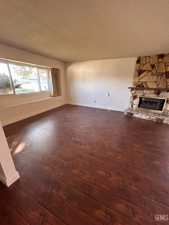 unfurnished living room featuring a textured ceiling, dark hardwood / wood-style flooring, and a fireplace