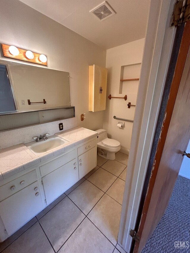 bathroom featuring tile patterned flooring, vanity, and toilet