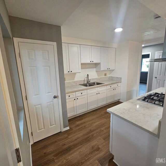 kitchen with white fridge, white cabinetry, dark wood-type flooring, and wall chimney range hood