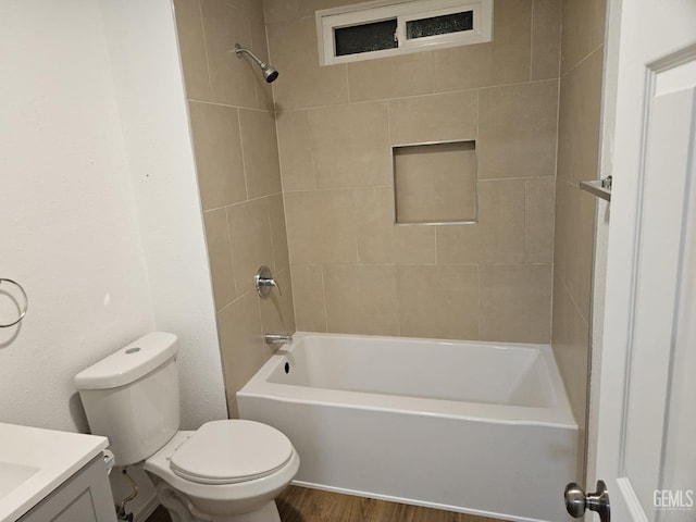 full bathroom with toilet, hardwood / wood-style flooring, tiled shower / bath combo, and vanity