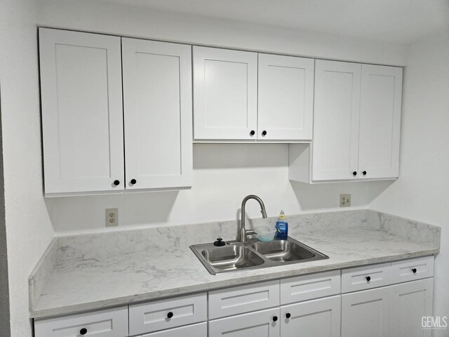 kitchen with sink, dark wood-type flooring, island exhaust hood, pendant lighting, and white cabinets