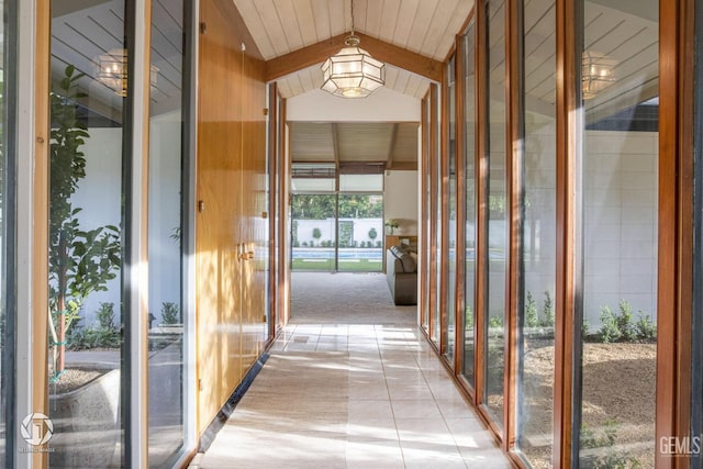 hallway with light tile patterned floors and lofted ceiling