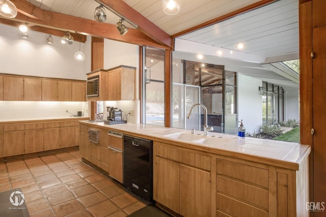 kitchen with wood ceiling, sink, tile countertops, black dishwasher, and stainless steel microwave