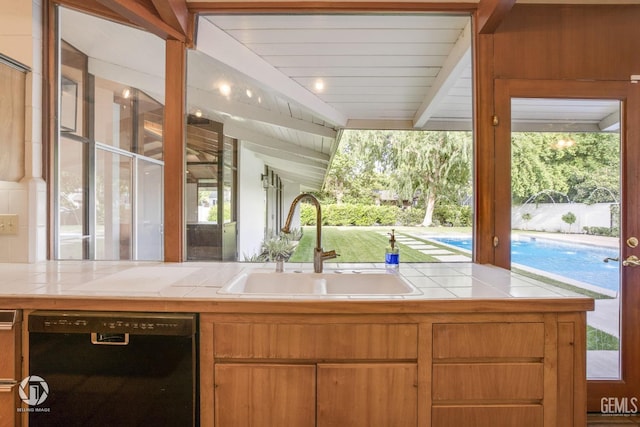 kitchen with black dishwasher, lofted ceiling with beams, plenty of natural light, and sink