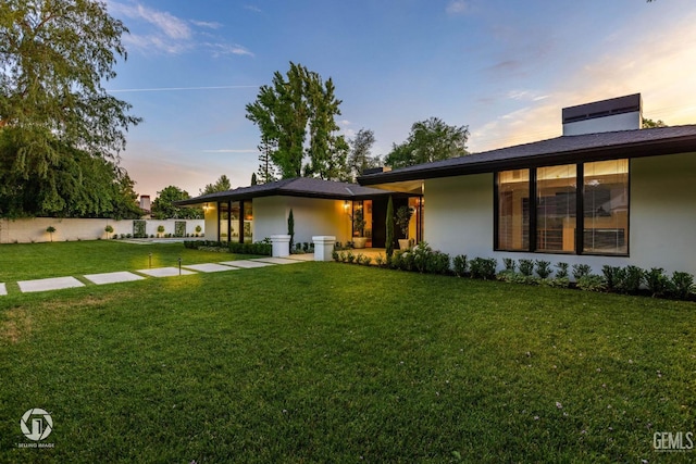 back house at dusk with a yard