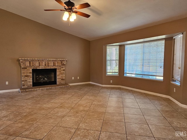 unfurnished living room with light tile patterned flooring, a brick fireplace, and ceiling fan