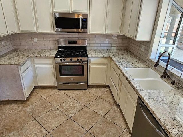 kitchen with backsplash, stainless steel appliances, light tile patterned floors, and sink