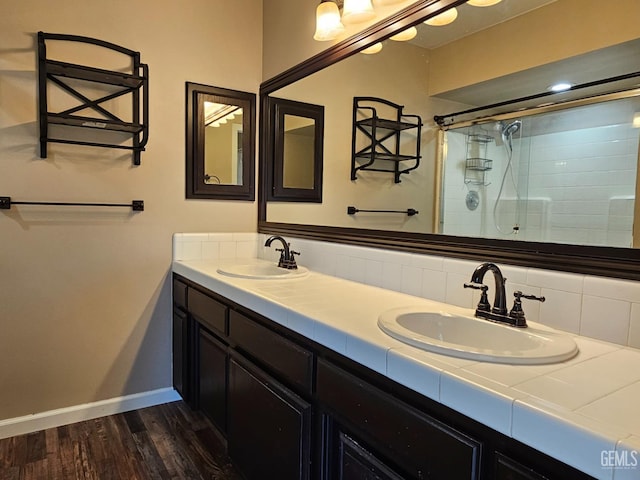 bathroom featuring hardwood / wood-style flooring, walk in shower, and vanity