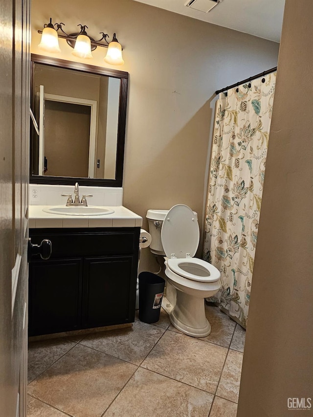 bathroom featuring toilet, a shower with shower curtain, and vanity