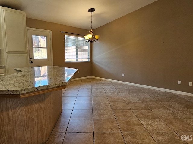 unfurnished dining area with light tile patterned floors and a notable chandelier