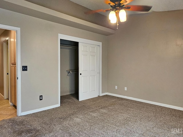 unfurnished bedroom with light carpet, a closet, and ceiling fan