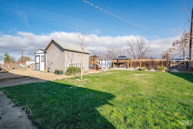 view of yard with a gazebo, a playground, and a storage unit