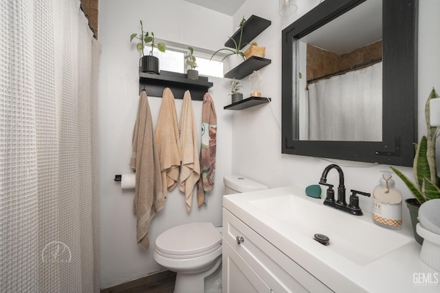 bathroom with vanity, toilet, and curtained shower