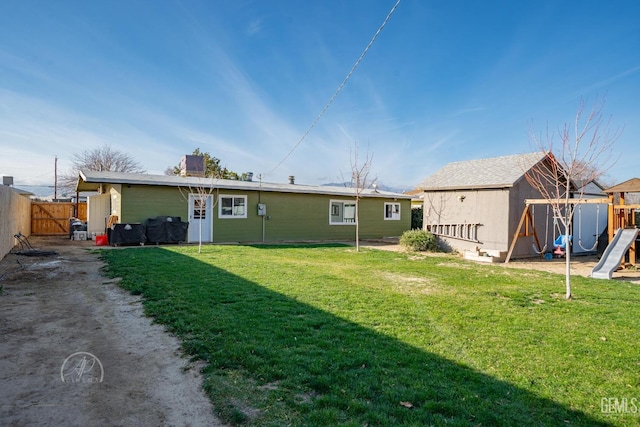 back of house with a playground, a shed, and a lawn