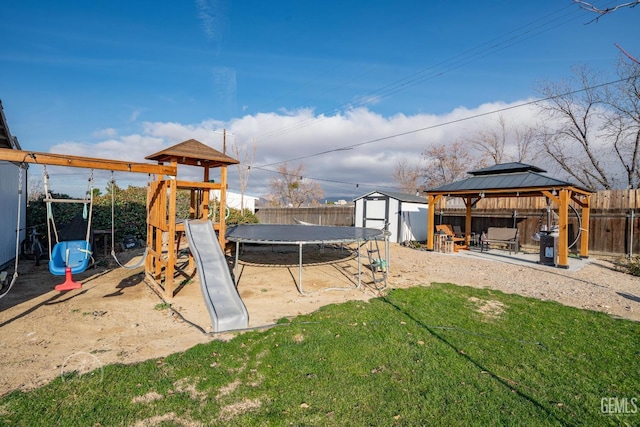 view of play area with a gazebo, a trampoline, a storage shed, and a lawn