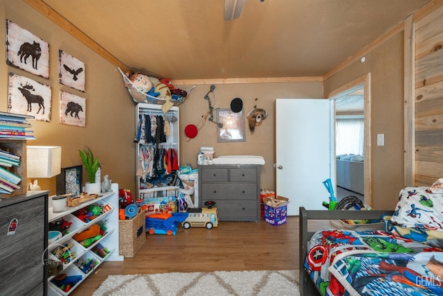 bedroom with hardwood / wood-style flooring, ceiling fan, and crown molding