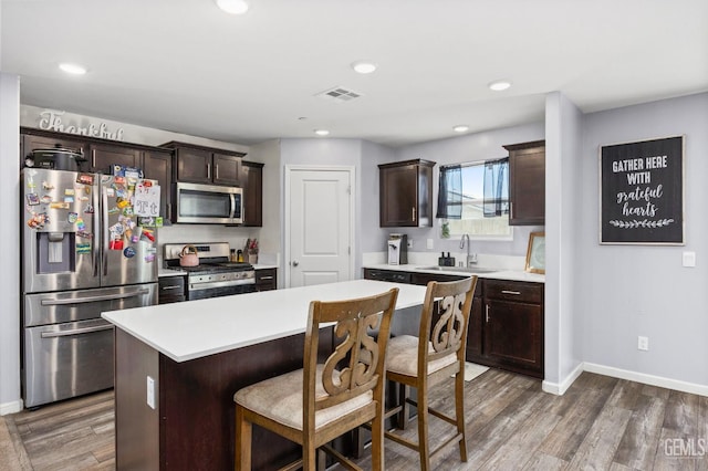 5803 Vespucci Ave, Bakersfield, CA 93313 - kitchen with appliances with stainless steel finishes, dark brown cabinetry, light countertops, wood finished floors, and recessed lighting